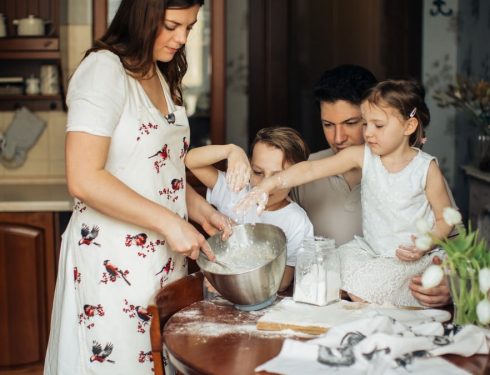 A family enjoys baking together in a cozy kitchen, sharing moments of love and happiness.